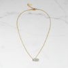 St. Lucia diamond solitaire necklace flat lay on white marble