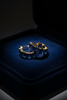 Kennedy blue sapphire stone huggie hoop earrings on dark velvet tray