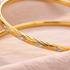 Doha two-tone gold bangle close-up engraved leaf detail