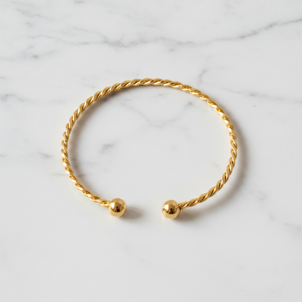 Kennedy gold twisted rope cuff bracelet flat lay on white marble