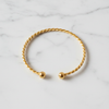 Kennedy gold twisted rope cuff bracelet flat lay on white marble