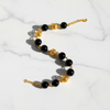 Elizabeth black resin and gold filigree ball bracelet flat lay on white marble