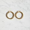 Efia gold plated twist hoop earrings flat lay on white marble