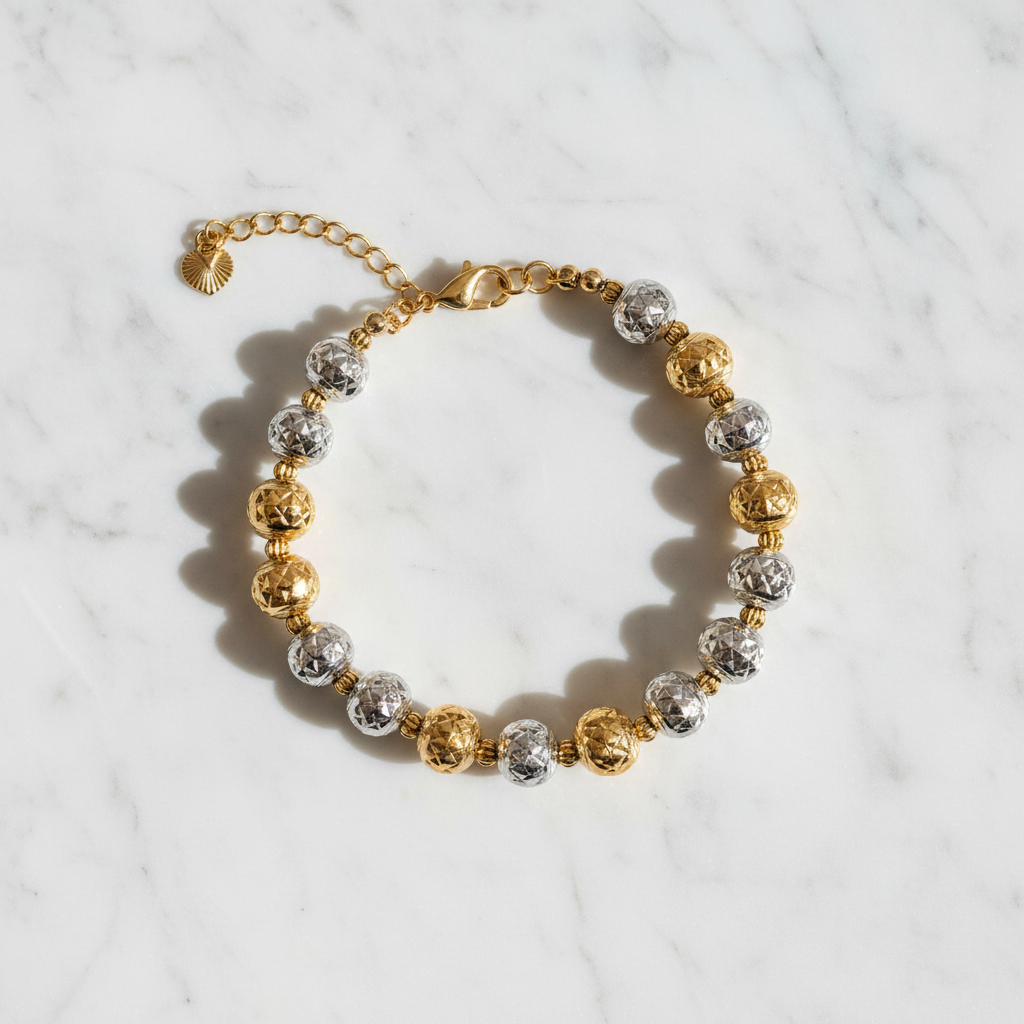 Oslo two-tone diamond-cut ball bracelet flat lay on white marble