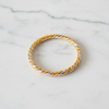 Capri two-tone twisted rope bangle bracelet flat lay on white marble