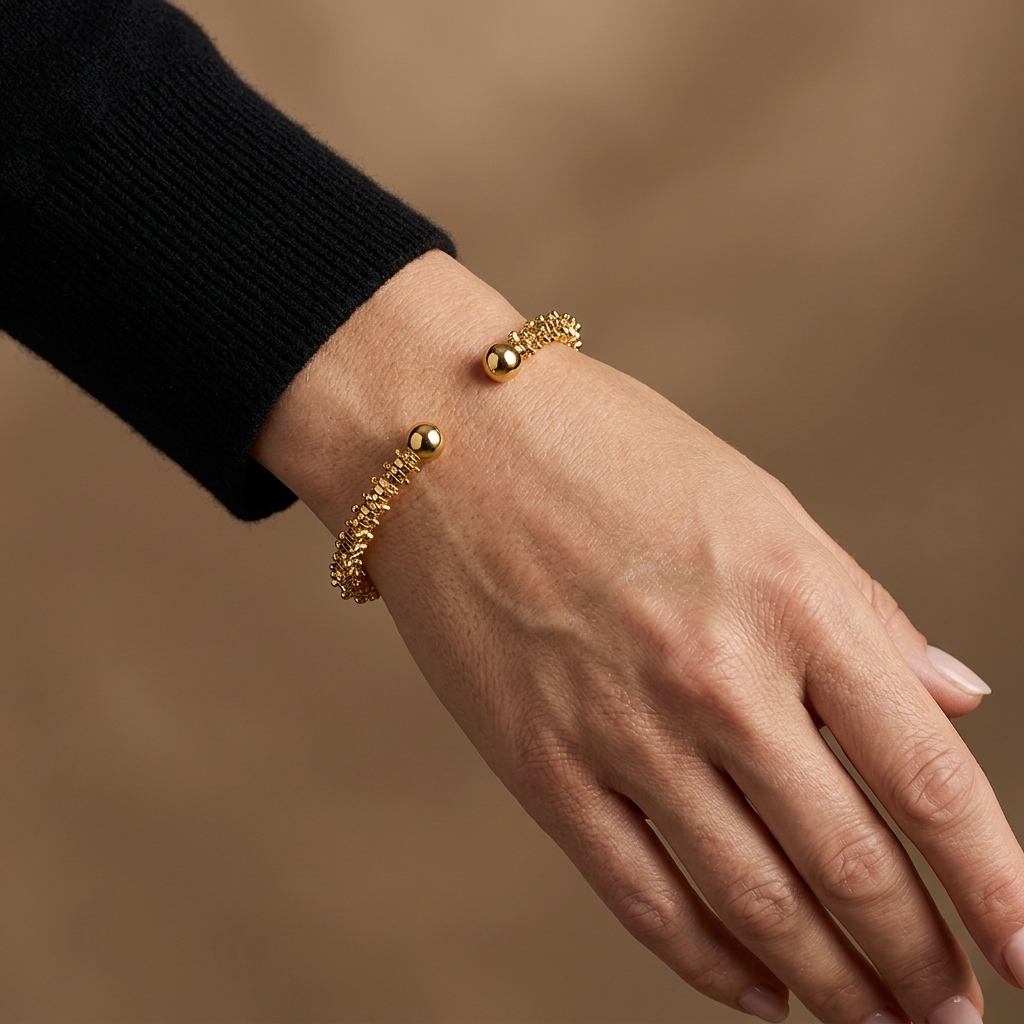 Carlisle gold-plated bracelet worn with a black sleeve