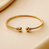 Kennedy gold twisted rope cuff bracelet close-up texture and ball end detail