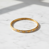Doha two-tone gold bangle flat lay on white marble