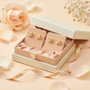 Oslo gold flower stud earrings gift-ready display on peach background