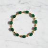 Halona cabochon emerald and gold bracelet flat lay on white marble