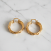 Cannes Sculptural Hoop Earrings - flat lay white marble