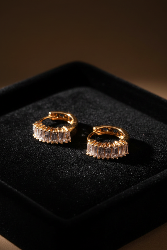 Capri gold plated baguette huggie earrings on dark velvet jewelry tray