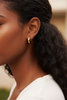 Alexa chunky gold huggie hoop earrings on-ear lifestyle editorial shot