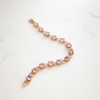 Winthrop tennis bracelet gold and pink oval-cut stones flat lay on white marble