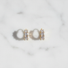 Kennedy white crystal stone huggie hoop earrings flat lay on white marble